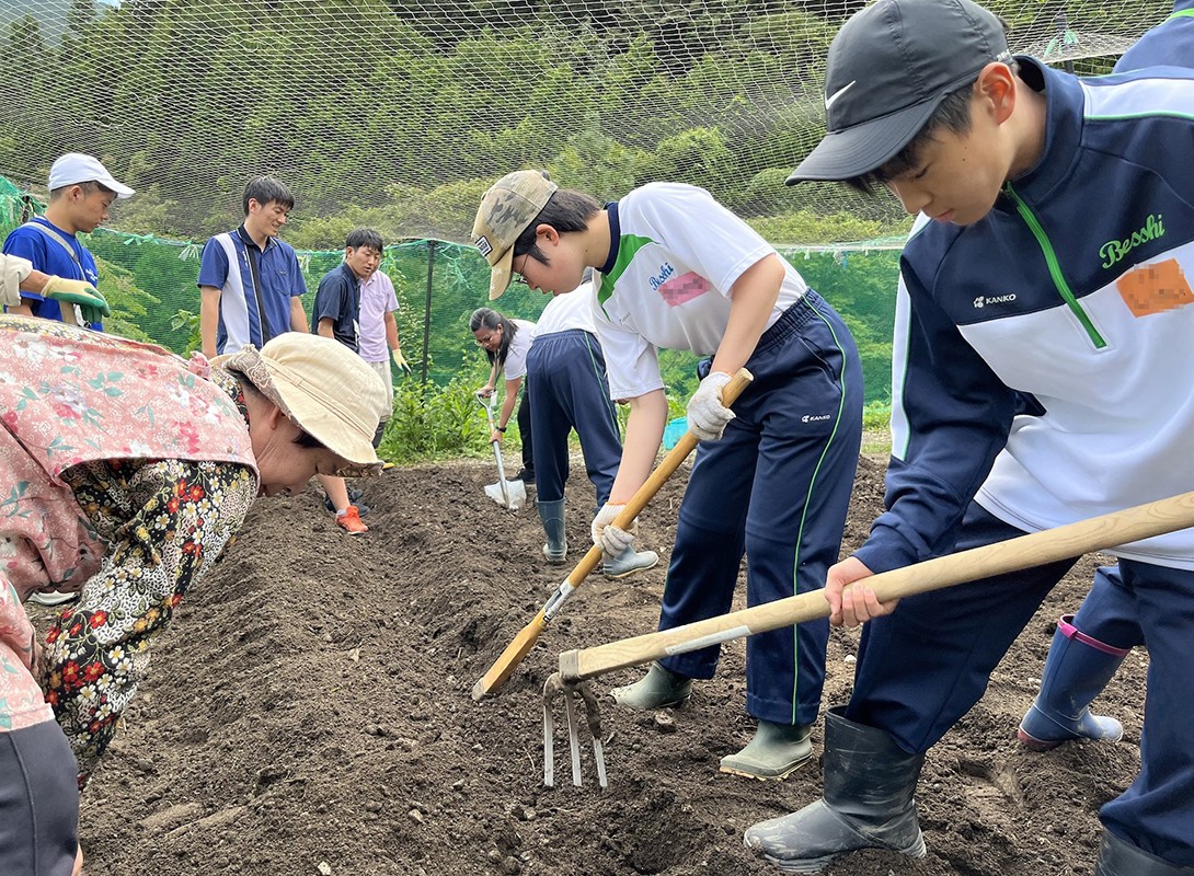 地域住民に教わりながら畑を耕す生徒たち
