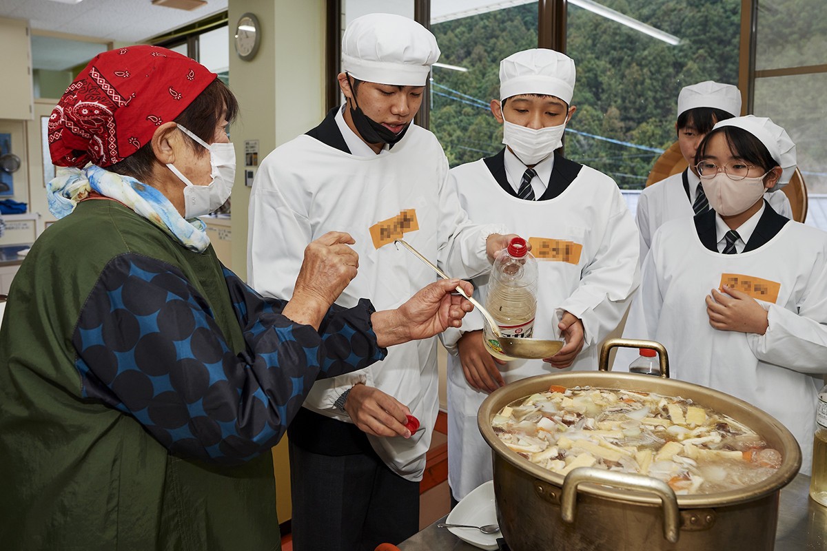 地域住民と一緒に猪鍋を作る生徒たち