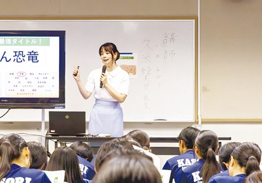 黒板の前でマイクを持って話す久米絵美里さん