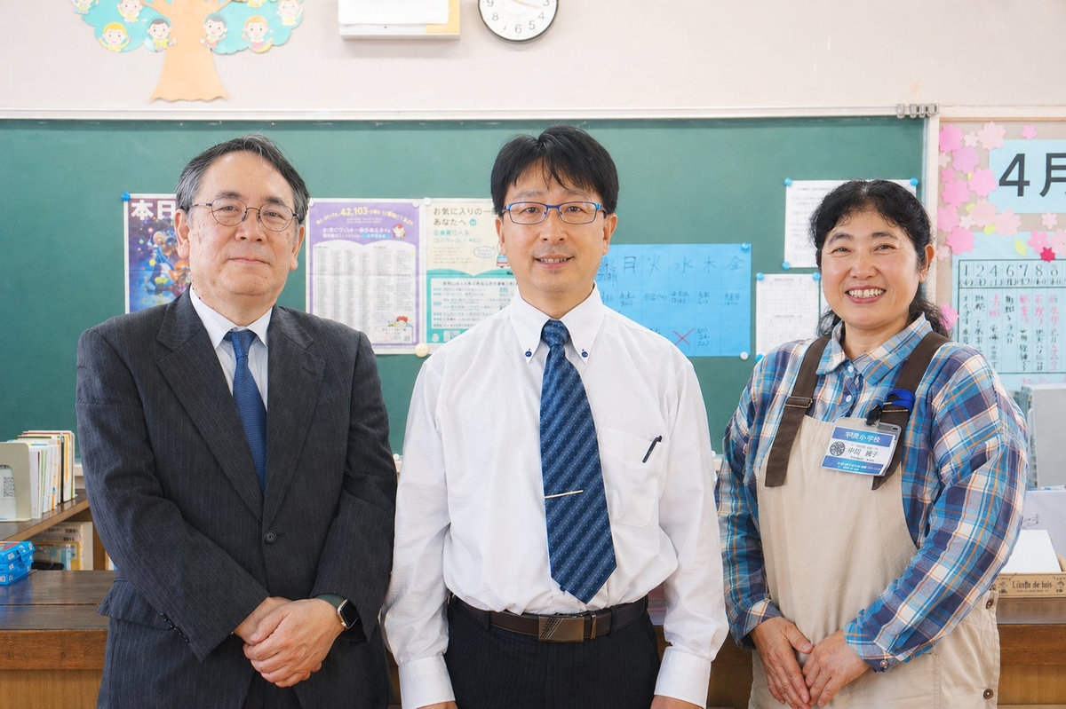 平群北小学校で写る中馬淳常務理事、森下展弥校長、中岡麻子司書