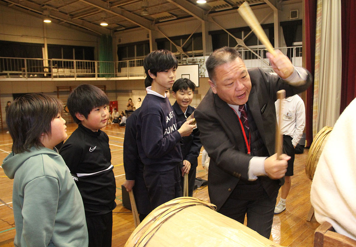 地域の指導者から直接手ほどきを受ける子どもたち