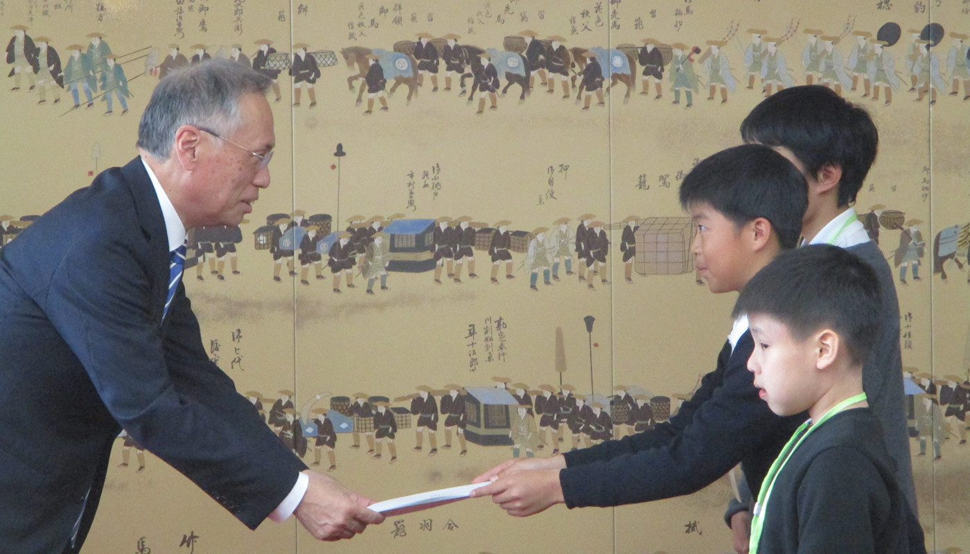 ラッピング電車の企画書を谷口圭三市長（当時）へ手渡す児童＝昨年１１月